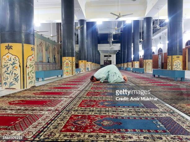 muslim man praying in prostration position inside a decorated mosque. - worshipper - fotografias e filmes do acervo