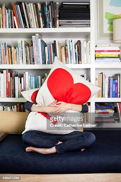 woman hugging heat pillows - cushion stockfoto's en -beelden