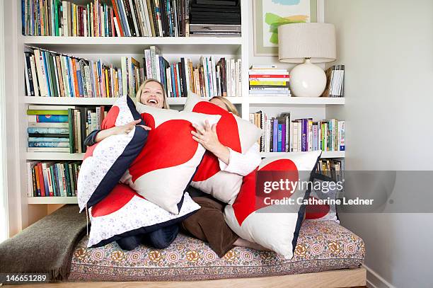 two women hugging heat shaped pillows - cushion stockfoto's en -beelden