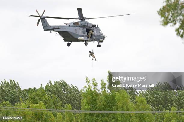 Helicopter winches a crew member down into Puketapu on February 16, 2023 in Napier, New Zealand. Cyclone Gabrielle has caused widespread destruction...