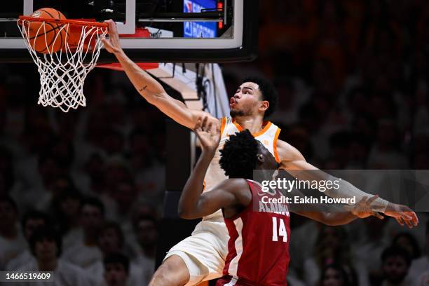 Olivier Nkamhoua of the Tennessee Volunteers dunks over Charles Bediako of the Alabama Crimson Tide in the first half at Thompson-Boling Arena on...