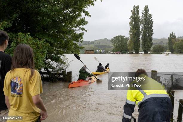 People are seen in canoes along the flood waters on February 14, 2023 in Gisborne, New Zealand. New Zealand has declared a national state of...