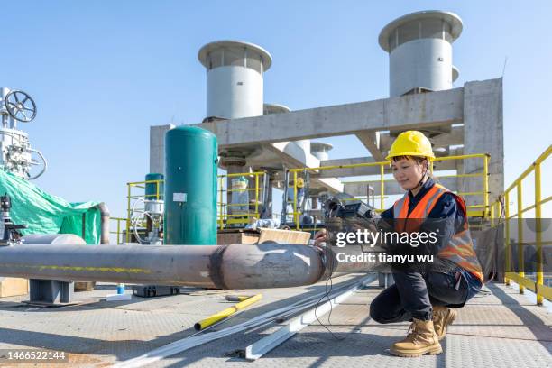 a female technician tested with electronic equipment in a chemical plant - glory tube 個照片及圖片檔