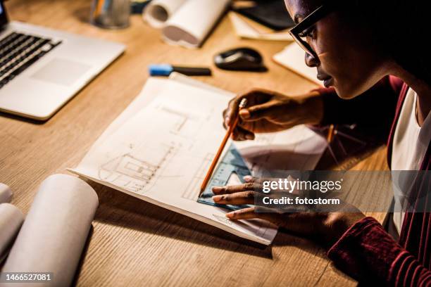 side view of female architect drawing a blueprint for a project - close up of blueprints stock pictures, royalty-free photos & images