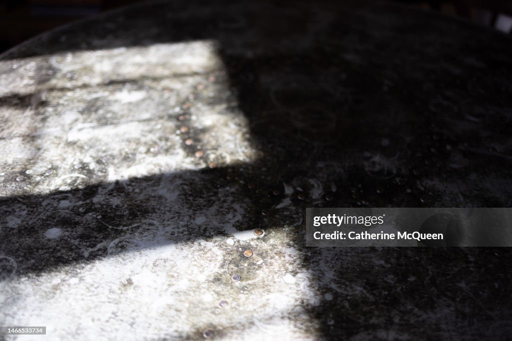 Galvanized metal detail on table top with shadows