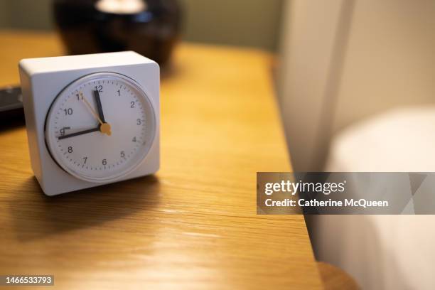 alarm clock on bedside table - daylight saving time foto e immagini stock
