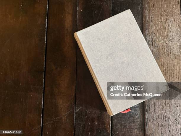 blank linen covered coffee table book on wooden table (copy space) - blank book cover stockfoto's en -beelden