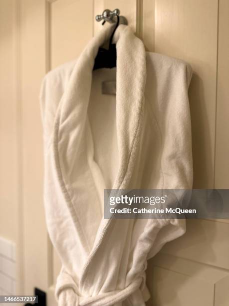 luxury bathrobe hanging on back of bathroom door - terry mcqueen stock-fotos und bilder