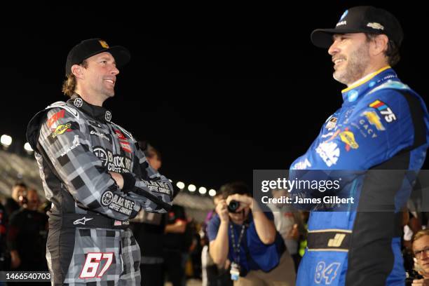 Travis Pastrana, driver of the Black Rifle Coffee Toyota, and Jimmie Johnson, driver of the Carvana Chevrolet, talk on the grid during qualifying for...