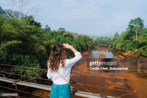 mujer parada en el puente y mirando el río tropical en el parque nacional khao wok - kao sok national park fotografías e imágenes de stock