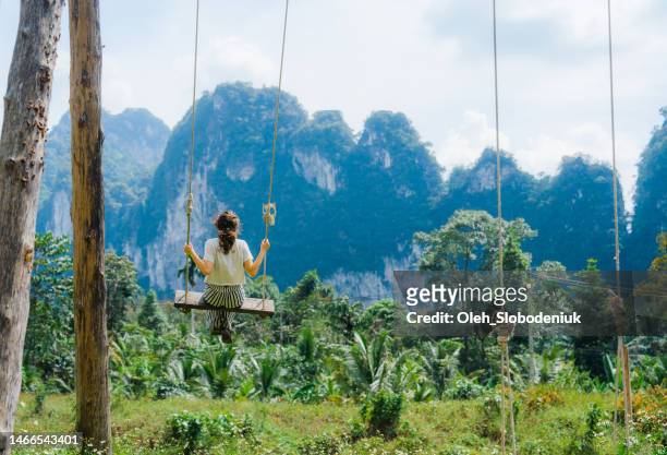 woman on the swing on the background of the jungles and mountains - kao sok national park stock pictures, royalty-free photos & images