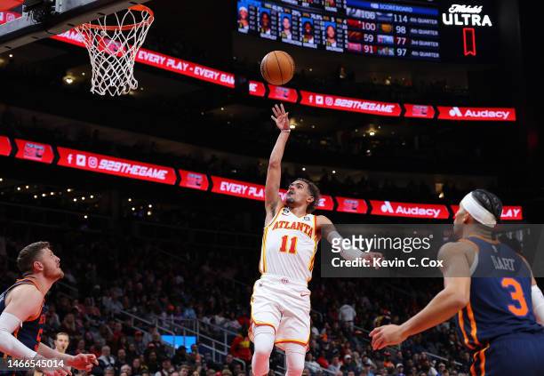 Trae Young of the Atlanta Hawks attempts a shot against Josh Hart and Isaiah Hartenstein of the New York Knicks during the third quarter at State...