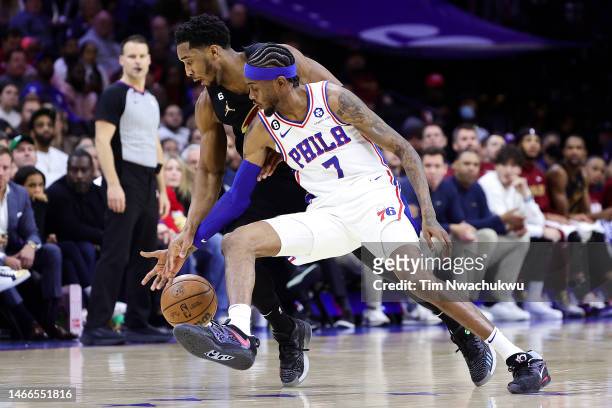 Donovan Mitchell of the Cleveland Cavaliers and Jalen McDaniels of the Philadelphia 76ers challenge for a loose ball during the third quarter at...