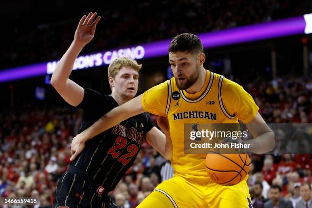 Hunter Dickinson of the Michigan Wolverines drives to the basket on Steven Crowl of the Wisconsin Badgers during the first half of the game at Kohl...