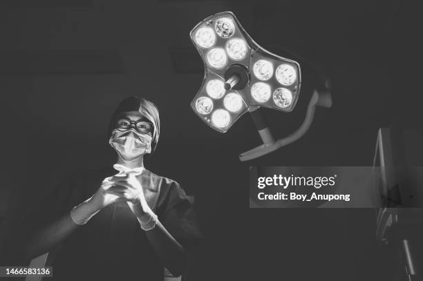 monochrome tone of female healthcare worker in surgical gown while working in operating room in hospital. - asian ceiling fotografías e imágenes de stock