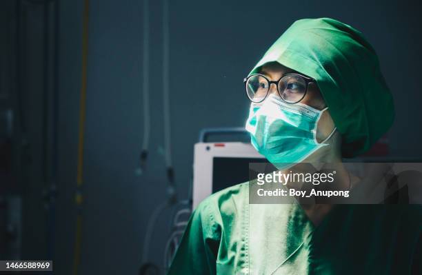 nurse in surgical gown while working in operating room in hospital. - determination doctor stock pictures, royalty-free photos & images