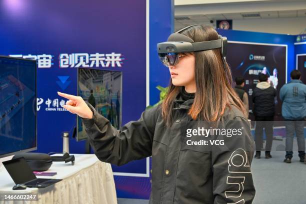Visitor wearing VR glasses experiences the virtual and real combination system of auto parts at a metaverse-themed exhibtion on February 15, 2023 in...
