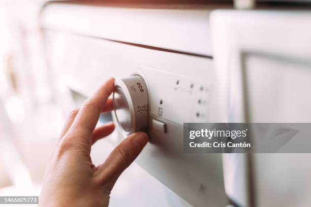 hand setting dishwasher to economy cycle - dishwasher stock pictures, royalty-free photos & images