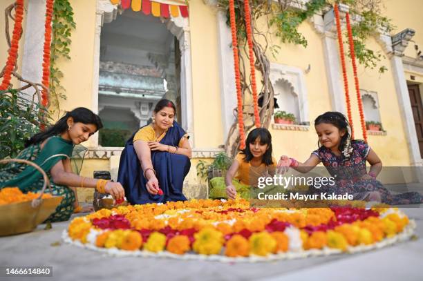 grandmother making beautiful flower rangoli with her grandchildren - preparation of gudi padwa festival stock pictures, royalty-free photos & images