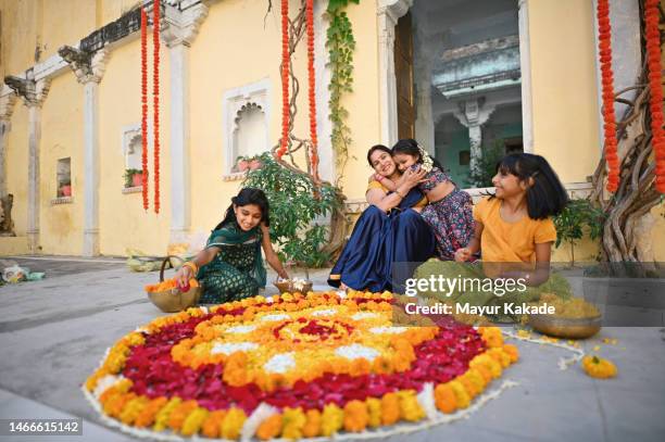 grandmother making beautiful flower rangoli with her grandchildren - preparation of gudi padwa festival stock pictures, royalty-free photos & images