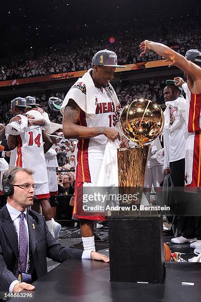 Mario Chalmers of the Miami Heat and teammates gather around the Larry O'Brien Championship trophy after the team's 121-106 victory against the...