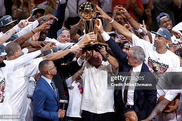 Team owner Micky Arison of the Miami Heat holds up the Larry O'Brien Championship trophy as he celebrates with his players after they won 121-106...