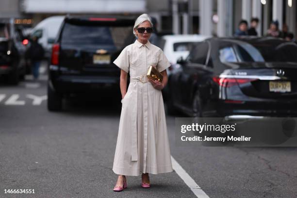 Grece Ghanem seen wearing a long white blouse dress, a golden Carolina Herrera bag, Gucci pink heels and dark shades before the Carolina Herrera show...