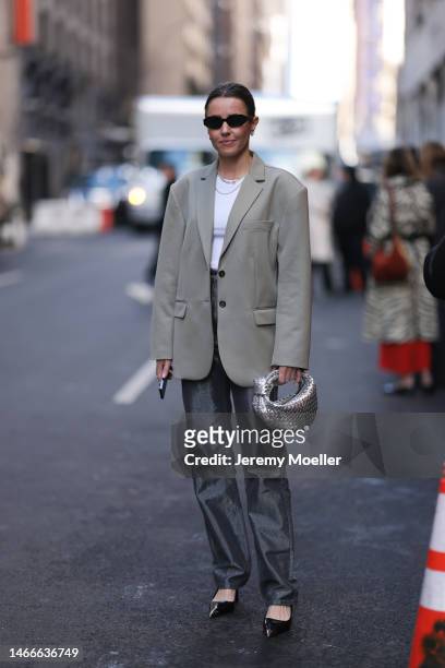 Chloe Street seen wearing a grey oversized blazer, a white shirt, silver jeans, dark heels by Prada and a silver bag by Bottega Veneta before the...