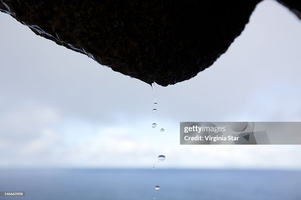Rainfall drops falling off rock