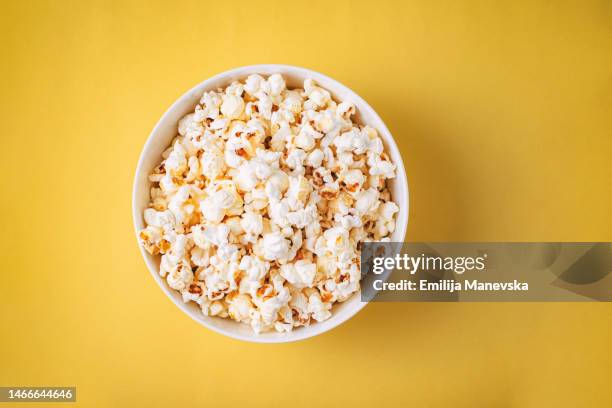 popcorn on yellow background - pop corn fotografías e imágenes de stock