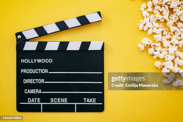 popcorn and clapboard on yellow background - film slate stock pictures, royalty-free photos & images