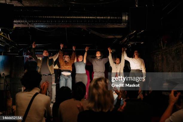 male and female actors holding hands on stage after performance in amateur theater - amateur theater stockfoto's en -beelden