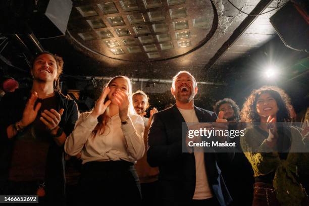 cheerful multiracial male and female audience giving standing ovation at theater - amateur theater stockfoto's en -beelden