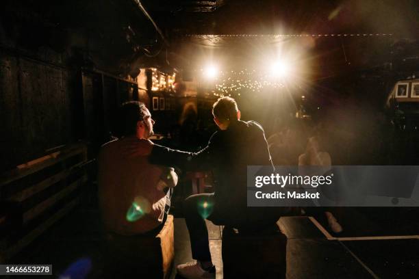 multiracial male actors performing on stage for audience at illuminated amateur theater - amateur theater stock pictures, royalty-free photos & images