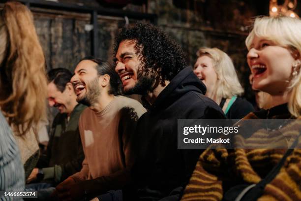 multiracial audience laughing while enjoying comedy show at amateur theater - arab old man fotografías e imágenes de stock