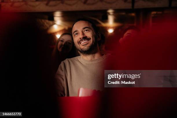 smiling man watching film at movie theater - spettatore foto e immagini stock