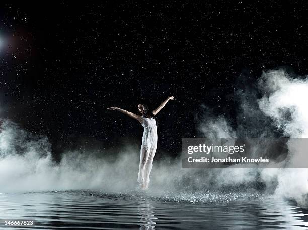 female in white dancing, rainy night - dry ice black background stock pictures, royalty-free photos & images