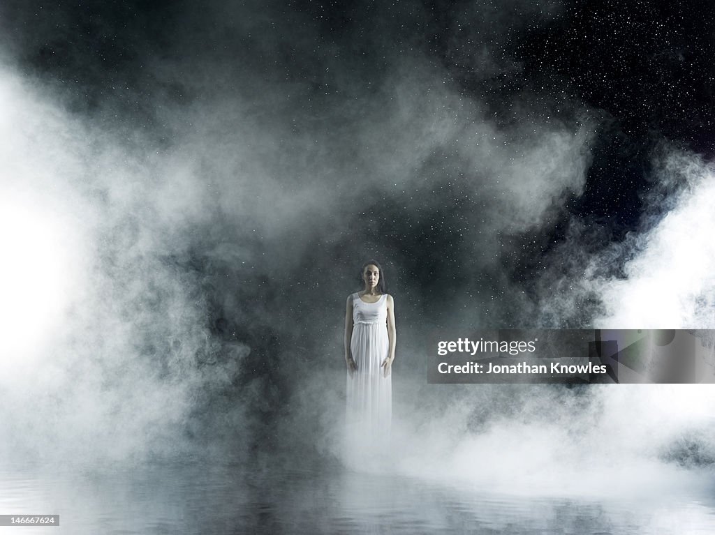 Female in white in rain,  misty night