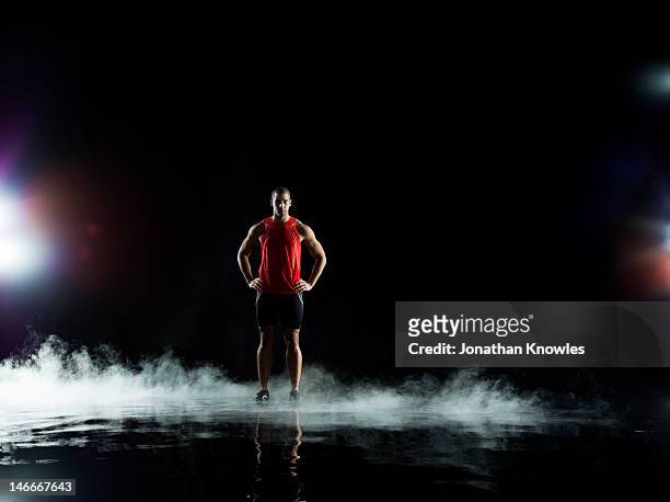 athelete standing in water at night - dry ice stock pictures, royalty-free photos & images