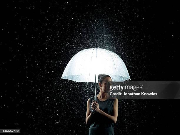 woman under umbrella in rain - opposite directions stock pictures, royalty-free photos & images