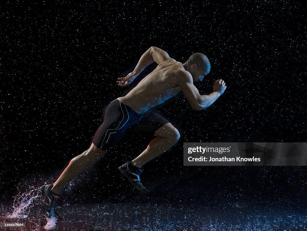 Athlete runner running through rain