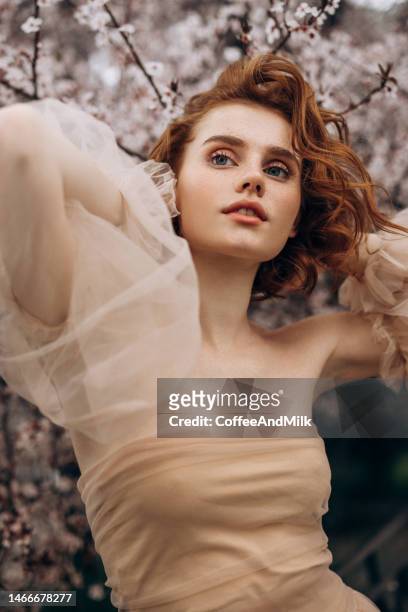 beautiful girl on the background of spring bush - floral pattern dress stock pictures, royalty-free photos & images