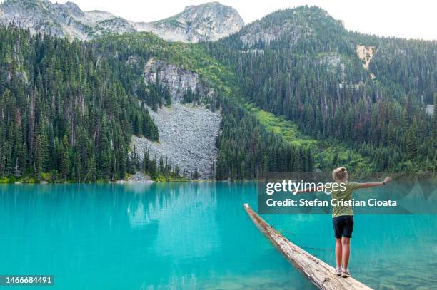 girl balancing on a fallen trunk on joffre upper lake canada - whistler british columbia stock pictures, royalty-free photos & images