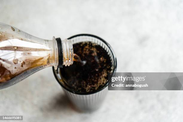 overhead view of glass of cola being poured - cola bottle photos et images de collection