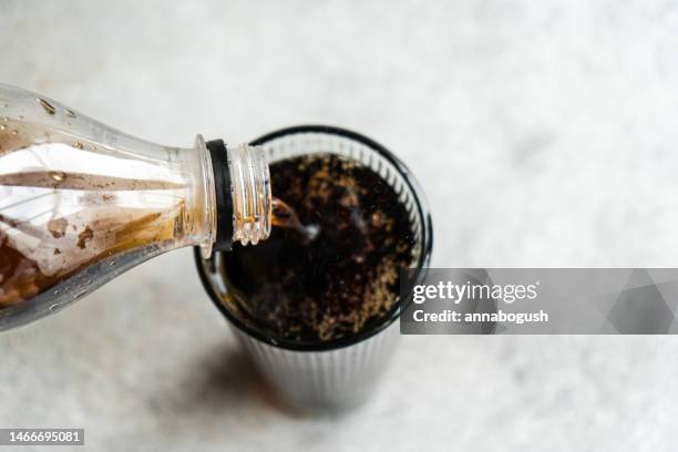 overhead view of glass of cola being poured - cola bottle stock pictures, royalty-free photos & images