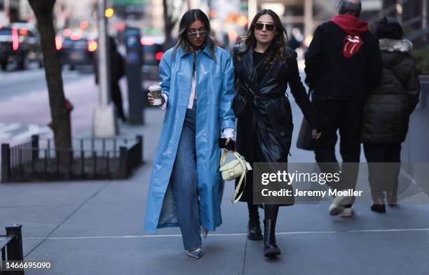 Fashion week guest seen wearing a blue long coat, a bag by Coach, shades and jeans and another fashion week guest seen wearing a black leather coat...