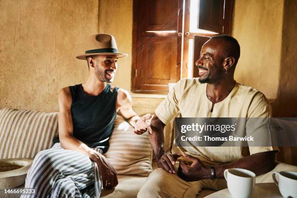 medium shot couple laughing together while having coffee at desert camp - beige hat stock pictures, royalty-free photos & images