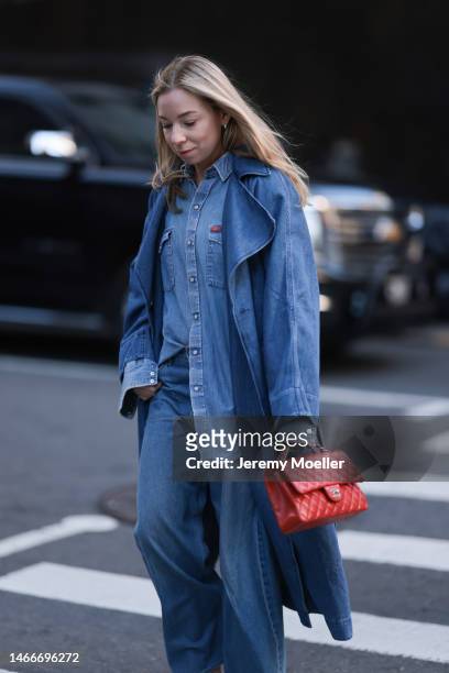 Fashion week guest seen wearing a total denim look with a denim blouse, a denim coat and denim wide leg pants and a Chanel red leather flap bag...