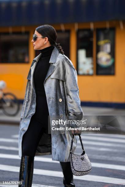 Alexandra Pereira wears black silver futurist sunglasses, silver and diamonds earrings, a black wool turtleneck pullover from Michael Kors, black...