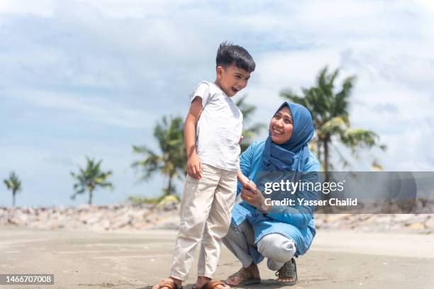 mother and son hanging out at a beach - kids fun indonesia stock-fotos und bilder